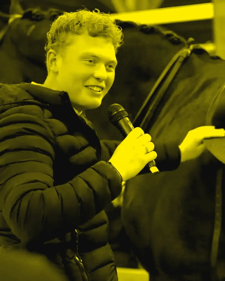 A brand presenter with a microphone next to a horse